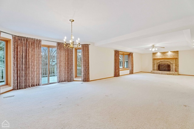 unfurnished living room featuring carpet, ceiling fan with notable chandelier, and a brick fireplace