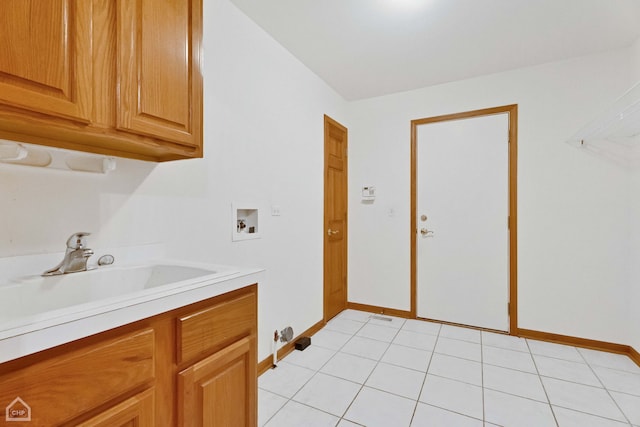 clothes washing area with sink, hookup for a washing machine, cabinets, and light tile patterned floors