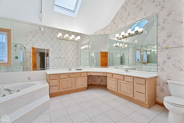 full bathroom featuring plus walk in shower, vaulted ceiling with skylight, tile patterned flooring, vanity, and toilet