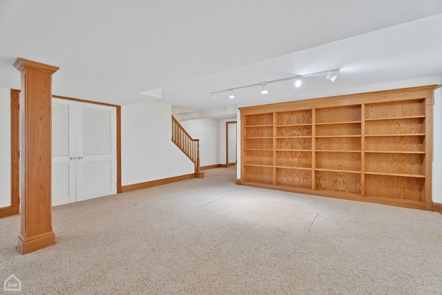 basement with track lighting and light colored carpet