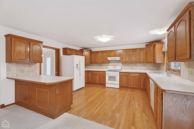 kitchen with sink, tasteful backsplash, light hardwood / wood-style flooring, kitchen peninsula, and white appliances