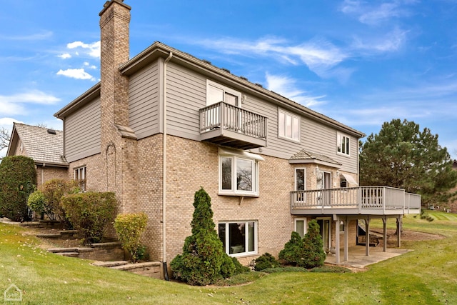 back of house with a wooden deck, a lawn, a patio, and a balcony