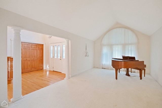 miscellaneous room with lofted ceiling, decorative columns, and carpet flooring