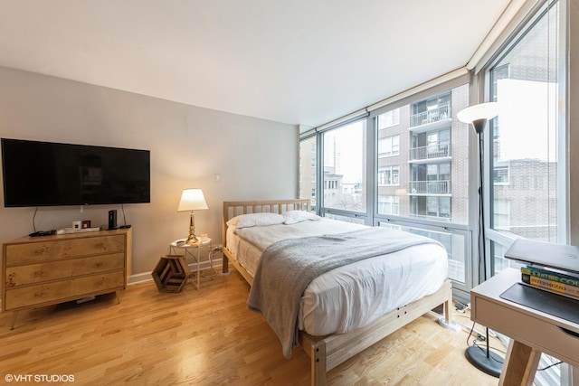 bedroom with light hardwood / wood-style flooring and floor to ceiling windows