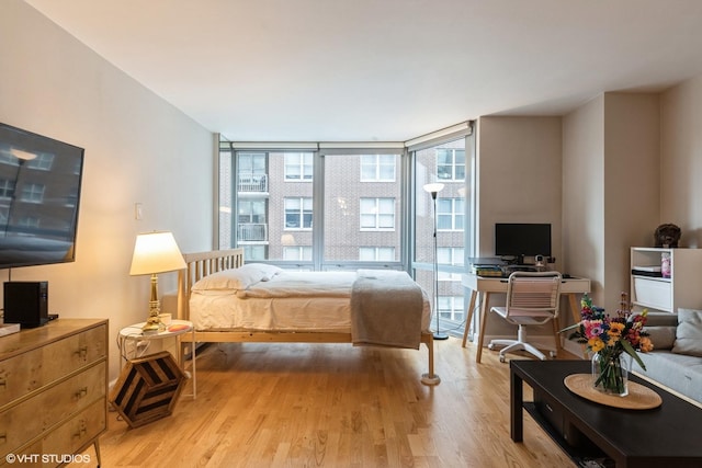 bedroom featuring expansive windows and light wood-type flooring