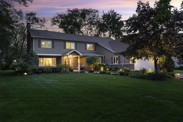 view of front of home with a garage and a yard