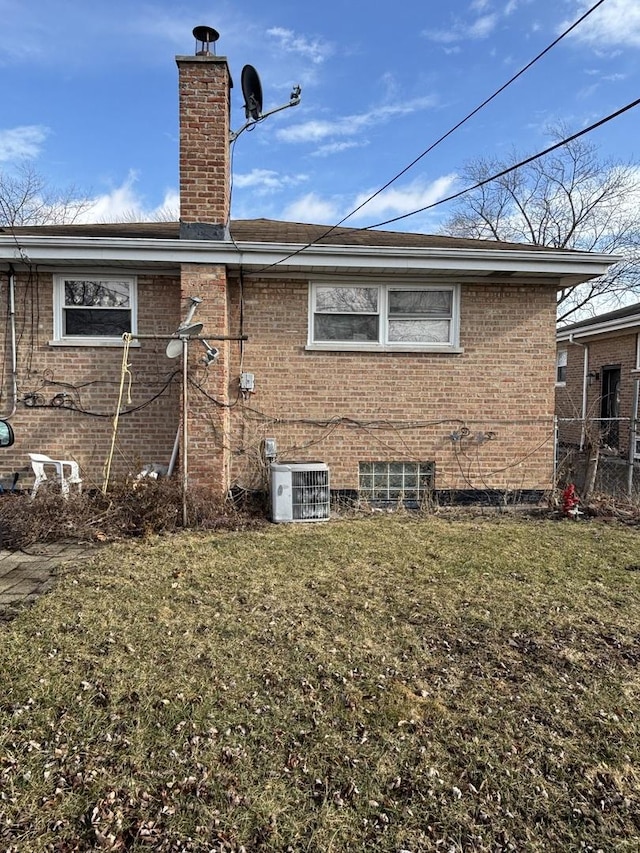 back of house with a yard and central AC unit