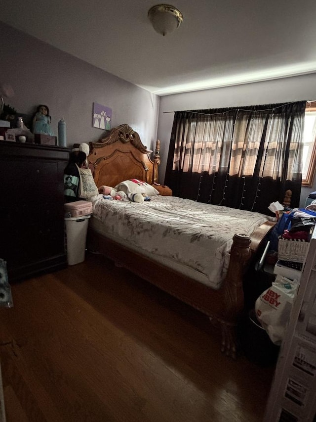 bedroom with dark hardwood / wood-style flooring