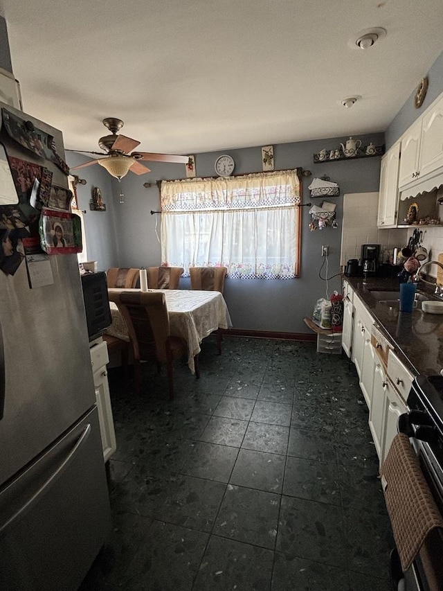 kitchen with sink, white cabinetry, range with electric stovetop, stainless steel refrigerator, and ceiling fan