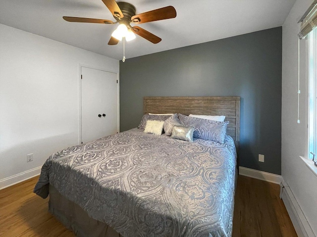 bedroom featuring dark hardwood / wood-style flooring, ceiling fan, and baseboard heating