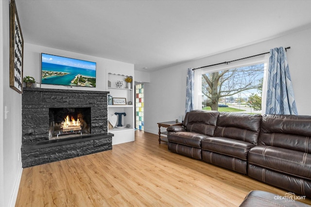 living room featuring hardwood / wood-style flooring, a fireplace, and built in shelves