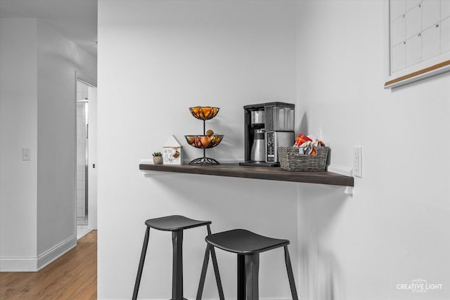 kitchen with wood-type flooring and a breakfast bar