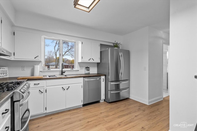 kitchen with white cabinetry, appliances with stainless steel finishes, sink, and light wood-type flooring