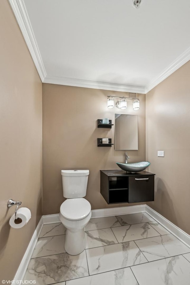 bathroom with vanity, ornamental molding, and toilet