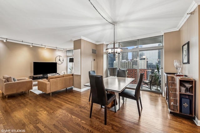 dining room with ornamental molding, rail lighting, hardwood / wood-style floors, and a notable chandelier