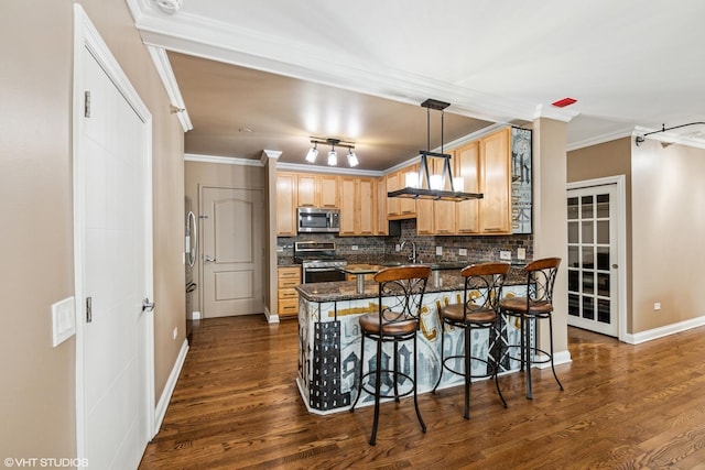 kitchen with appliances with stainless steel finishes, a breakfast bar, hanging light fixtures, kitchen peninsula, and crown molding