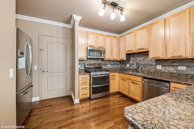 kitchen featuring light brown cabinetry, sink, dark stone counters, stainless steel appliances, and backsplash