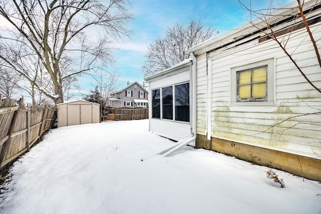 yard covered in snow with a storage shed