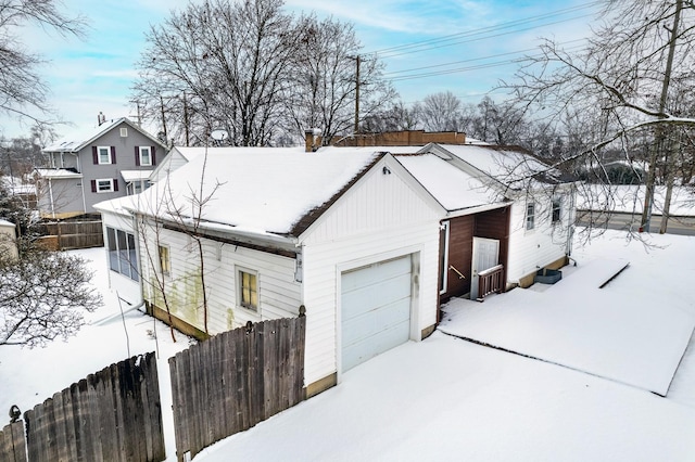 snow covered property with a garage