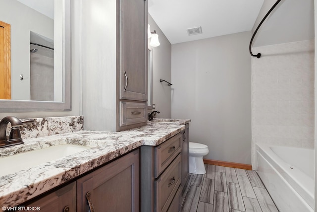 full bathroom featuring vanity, bathtub / shower combination, and toilet