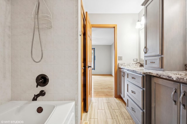 bathroom with vanity and tiled shower / bath