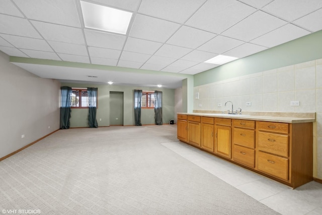 kitchen with light carpet, sink, and a paneled ceiling