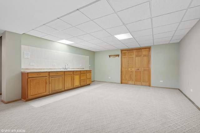 bar with a paneled ceiling, sink, and light carpet