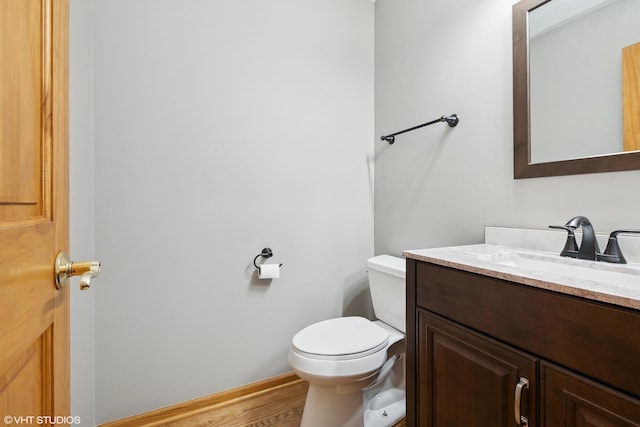 bathroom featuring vanity, hardwood / wood-style floors, and toilet