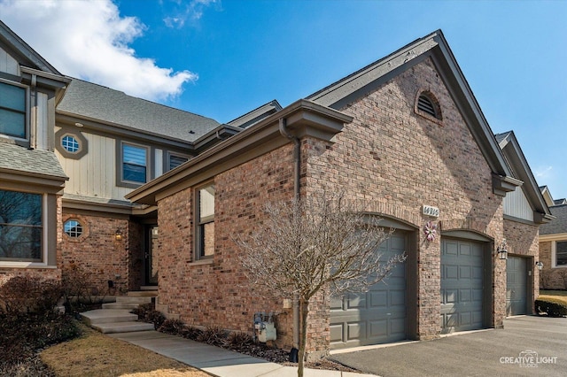 view of side of property featuring brick siding and an attached garage