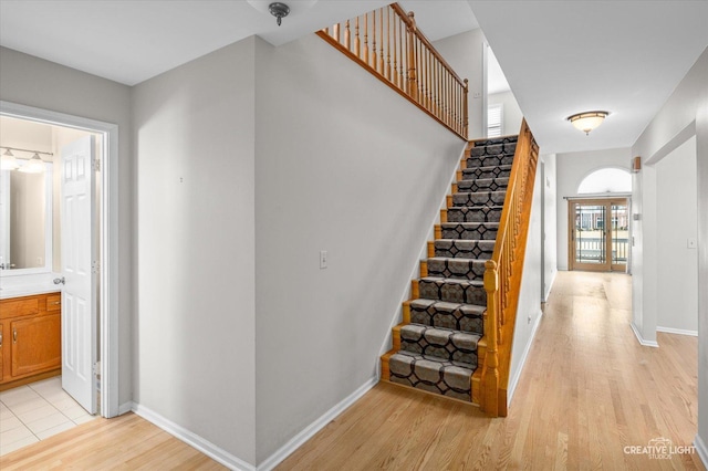 staircase featuring baseboards and wood finished floors