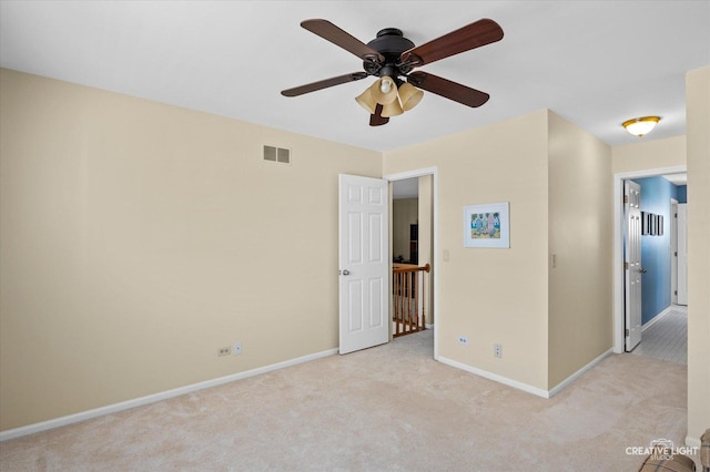 unfurnished bedroom featuring a ceiling fan, visible vents, light carpet, and baseboards