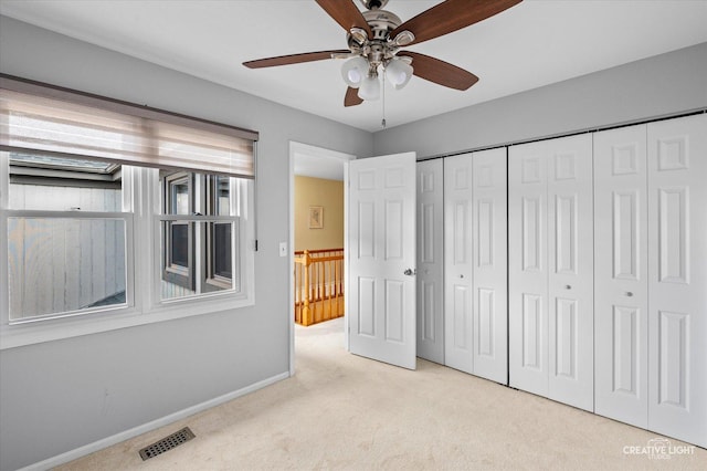 unfurnished bedroom with carpet, a closet, visible vents, a ceiling fan, and baseboards