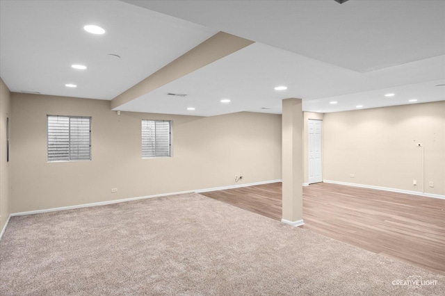 finished basement featuring baseboards, visible vents, light colored carpet, and recessed lighting