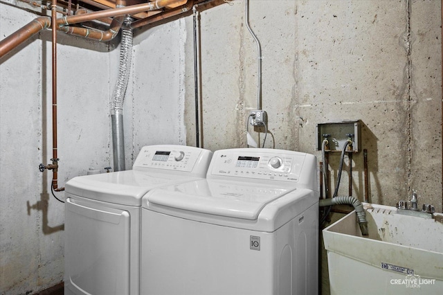 laundry room featuring laundry area, washing machine and clothes dryer, and a sink