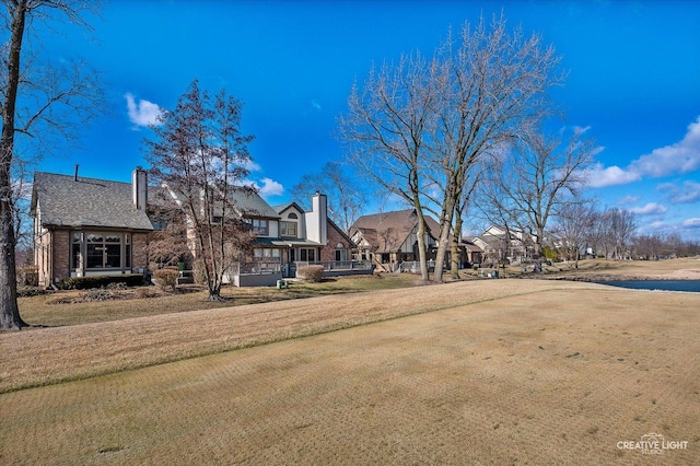 view of front of property with a chimney, a front yard, and a residential view