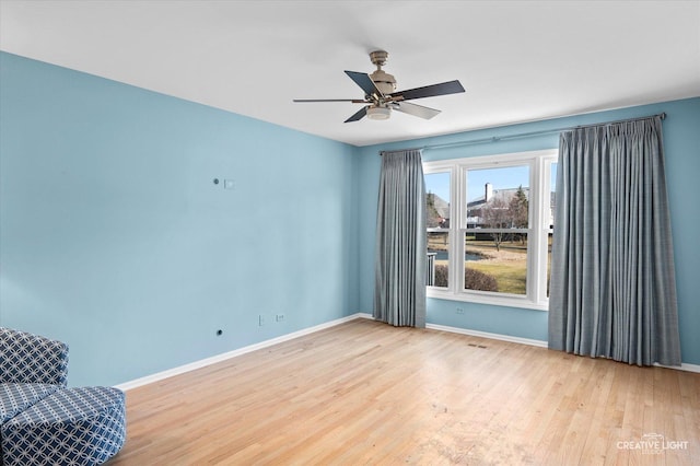 unfurnished room with a ceiling fan, baseboards, and wood finished floors