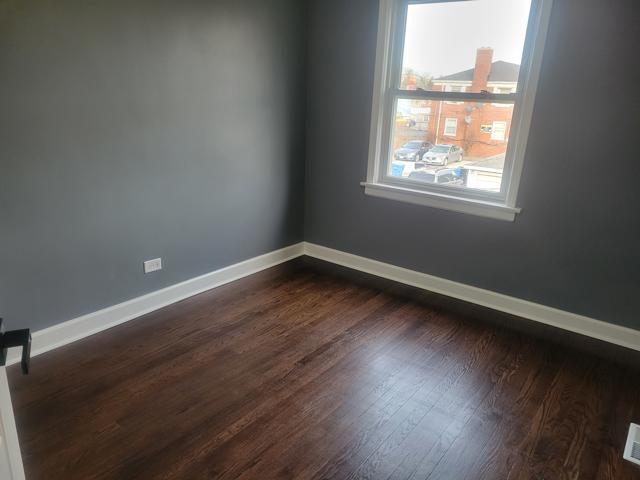 spare room with dark hardwood / wood-style flooring