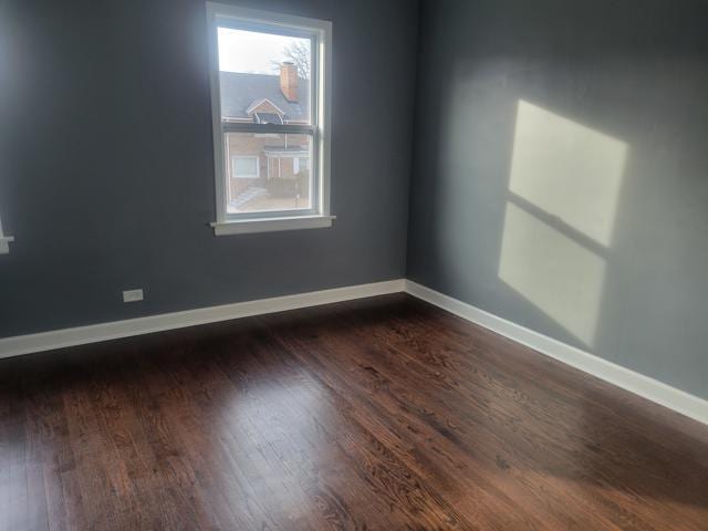 unfurnished room with dark wood-type flooring