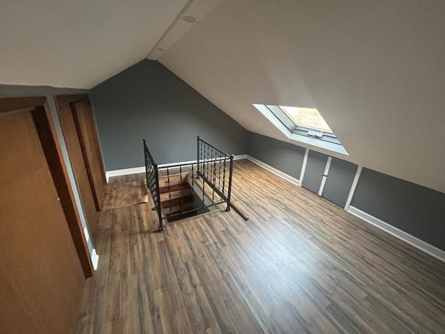 bonus room featuring wood-type flooring and lofted ceiling with skylight