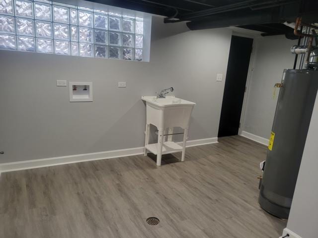 clothes washing area featuring hookup for a washing machine, gas water heater, and wood-type flooring