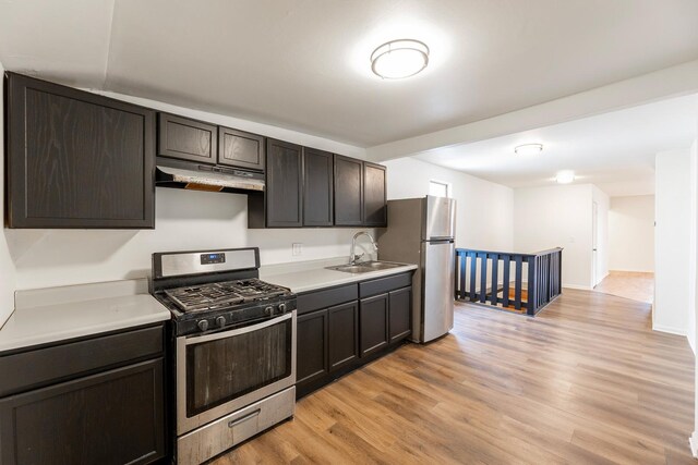 kitchen featuring dark brown cabinetry, sink, light hardwood / wood-style flooring, and stainless steel appliances