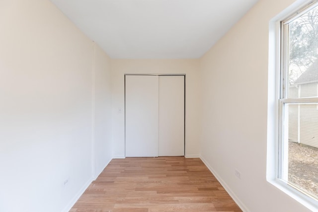 unfurnished bedroom featuring a closet and light hardwood / wood-style flooring