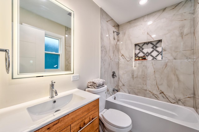 full bathroom with tiled shower / bath, vanity, and toilet