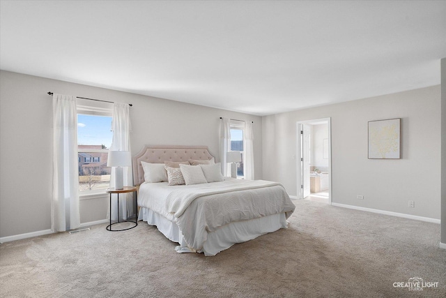 carpeted bedroom with ensuite bath, visible vents, and baseboards