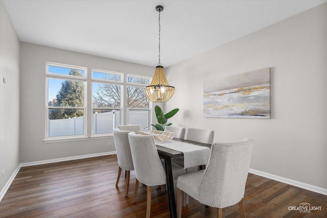 dining space featuring dark wood-style floors, a chandelier, and baseboards