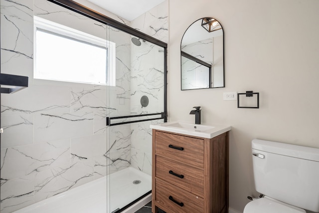 bathroom with vanity, toilet, and a shower with door