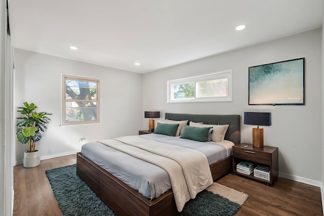 bedroom with dark wood-type flooring and multiple windows