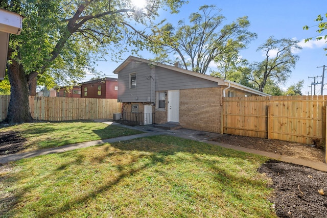 back of property featuring central AC unit and a lawn