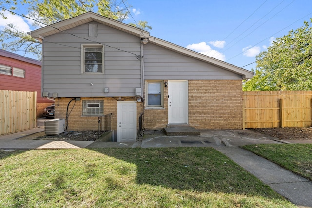 back of property featuring central AC and a lawn