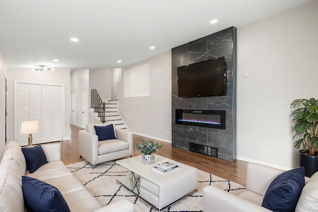 living room featuring a large fireplace and light wood-type flooring